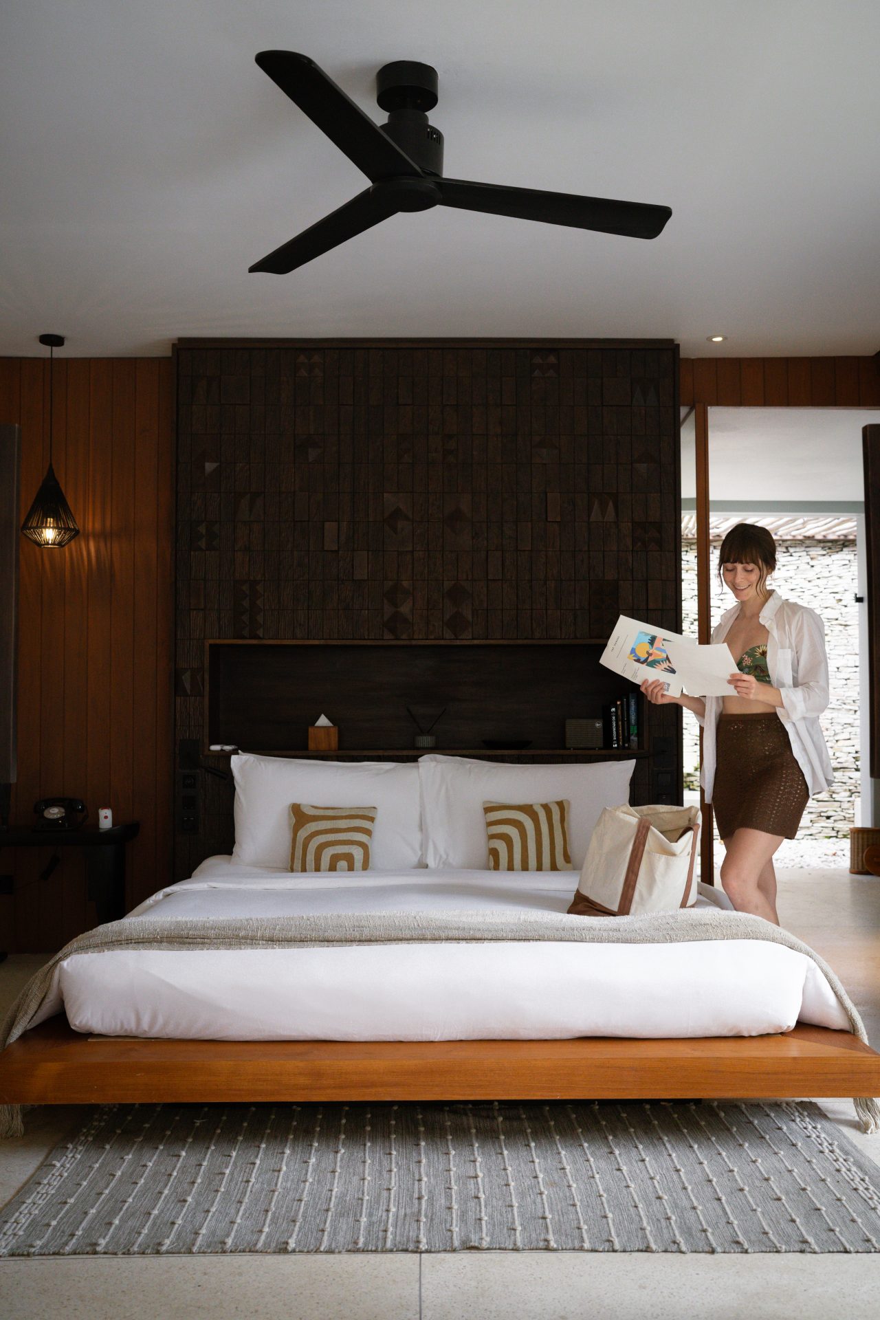 Travel Blogger Jordan Gassner packing a beach bag inside the Beach Suite bedroom at Cap Karoso resort in Sumba, Indonesia