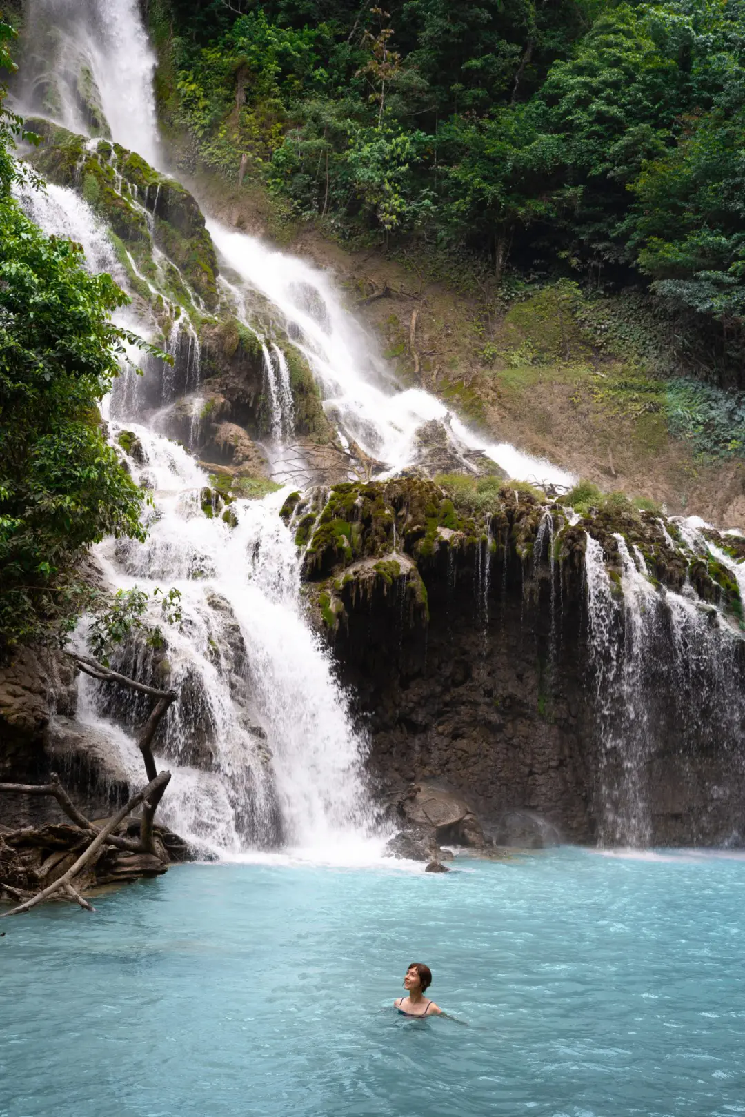 Travel Blogger Jordan Gassner swimming at the base of Lapopu Waterfall in Sumba, Indonesia