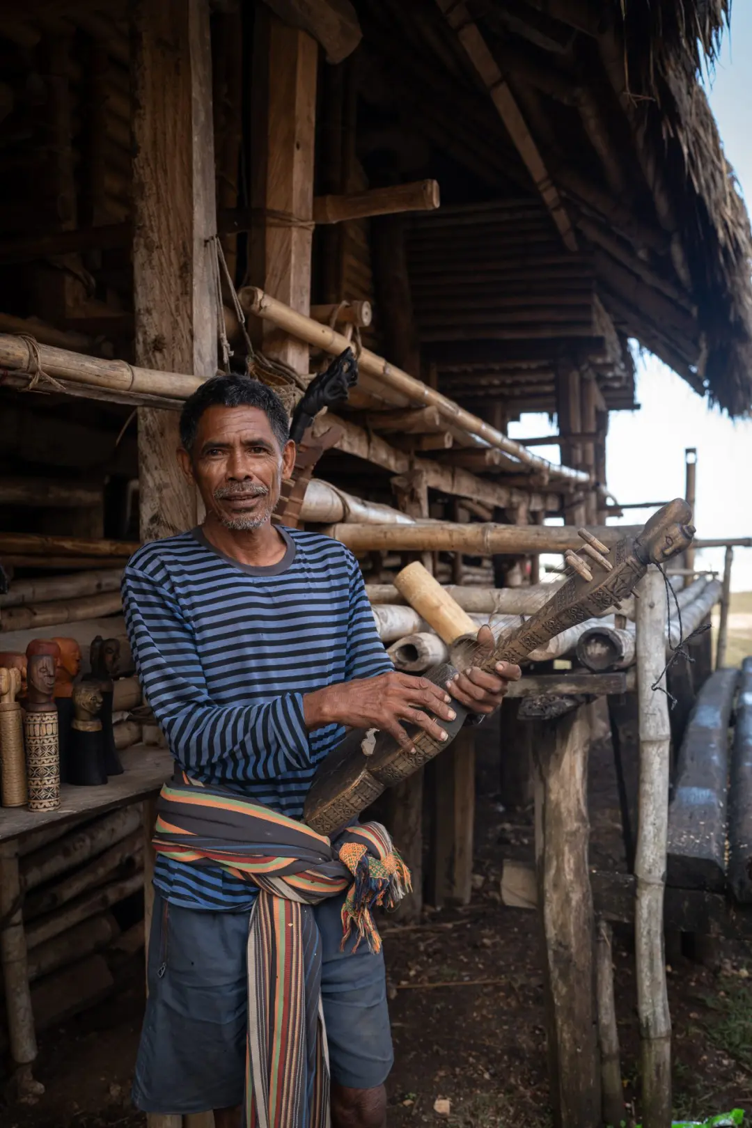 A local musician and artist at the traditional village of Ratenggaro in Sumba, Indonesia
