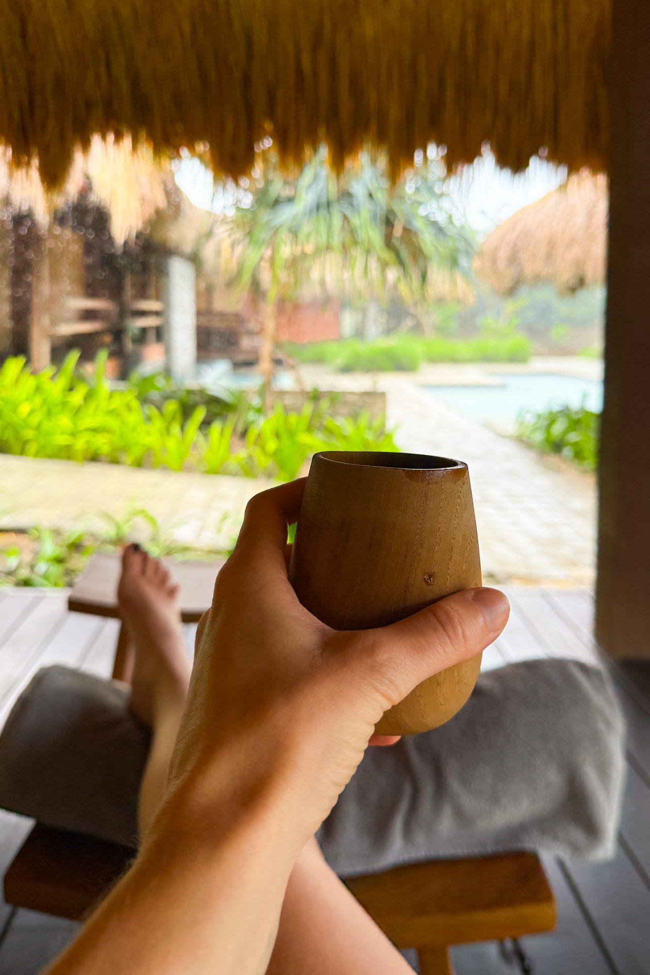 Travel Blogger Jordan Gassner holding a tea after a pedicure treatment at Malala Spa front desk at Cap Karoso Resort in Sumba, Indonesia