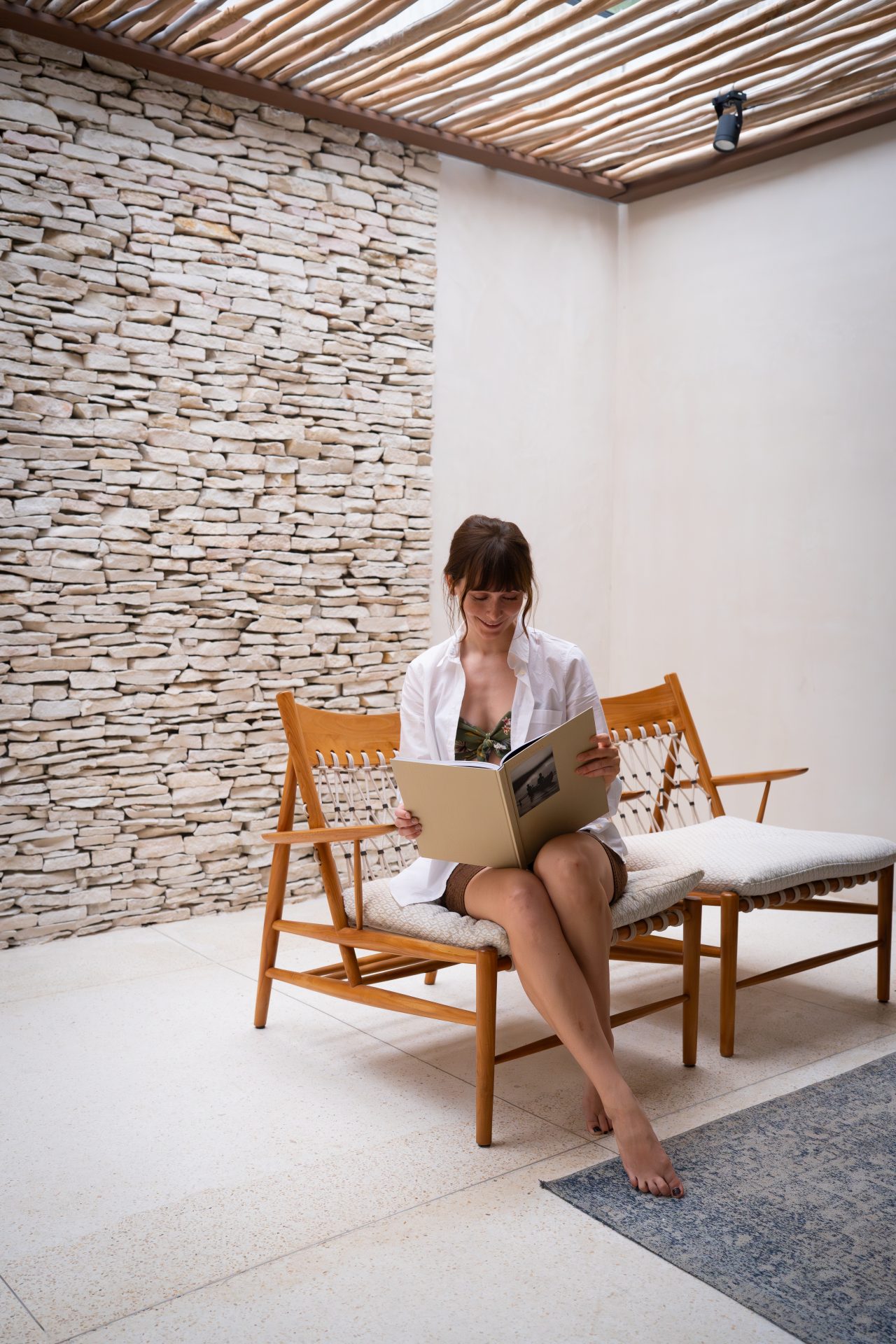 Travel Blogger Jordan Gassner looking through the branded hotel hardcover book in one of the guest rooms at Cap Karoso resort in Sumba, Indonesia
