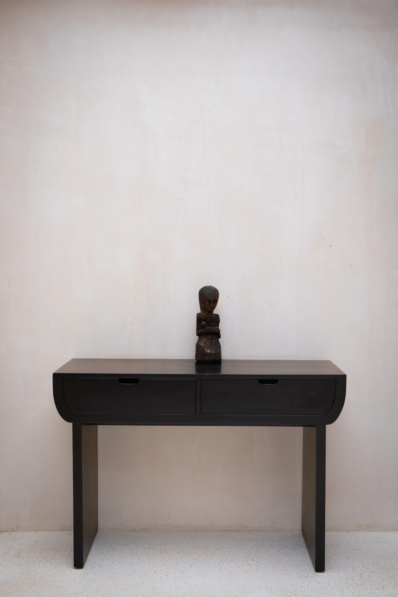 A table with a carving on it inside one of the Beach Suites at Cap Karoso resort in Sumba, Indonesia