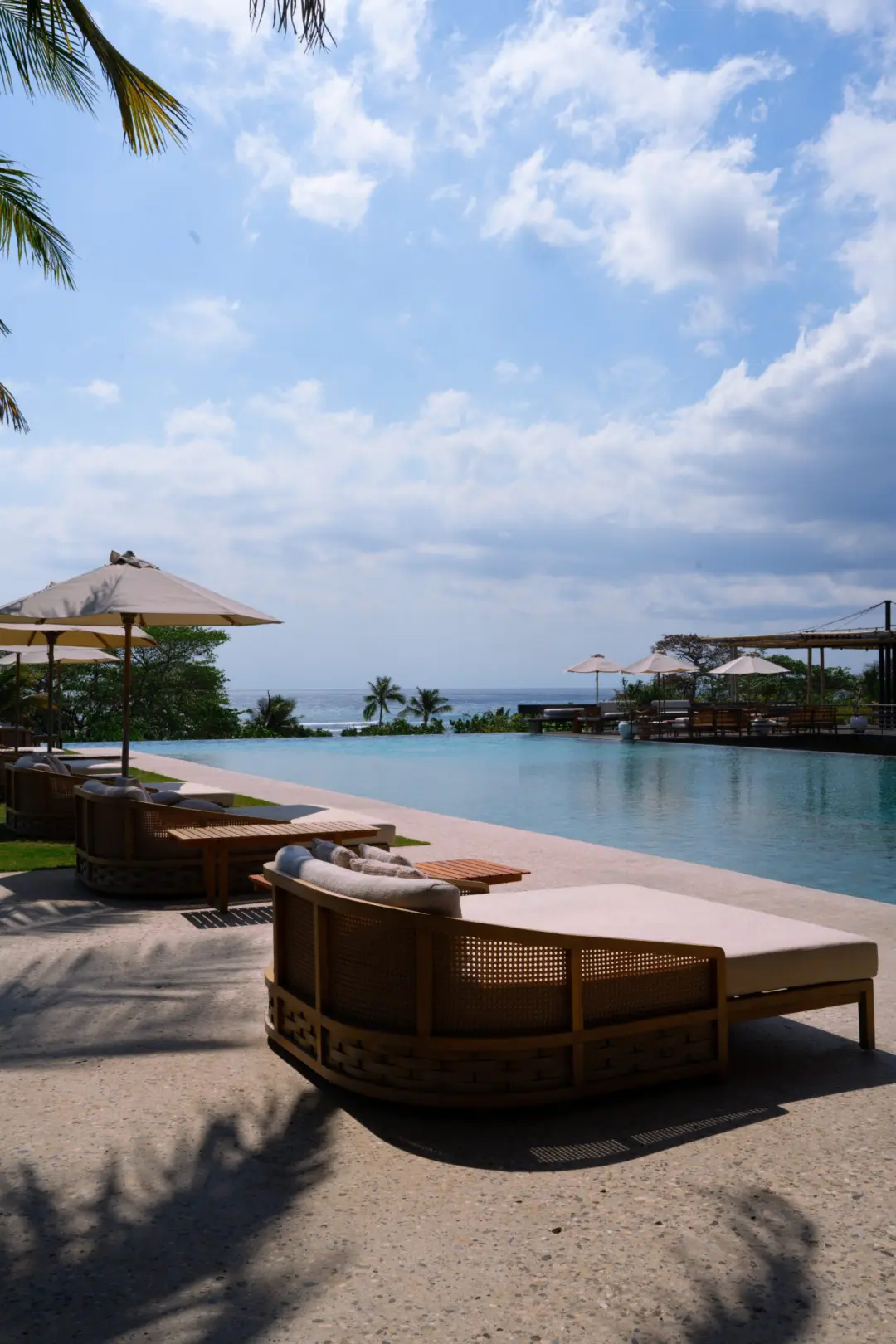 Lounge chairs near an infinity pool overlooking the ocean in Sumba, Indonesia