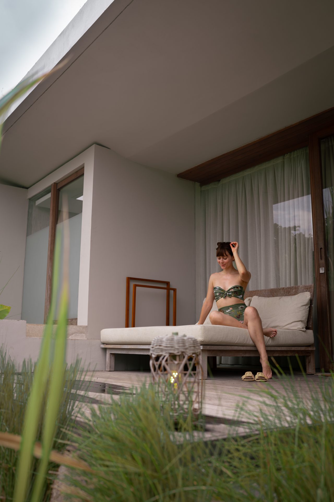 Travel Blogger Jordan Gassner lounging on a daybed outside of a guest room at Cap Karoso resort in Sumba, Indonesia