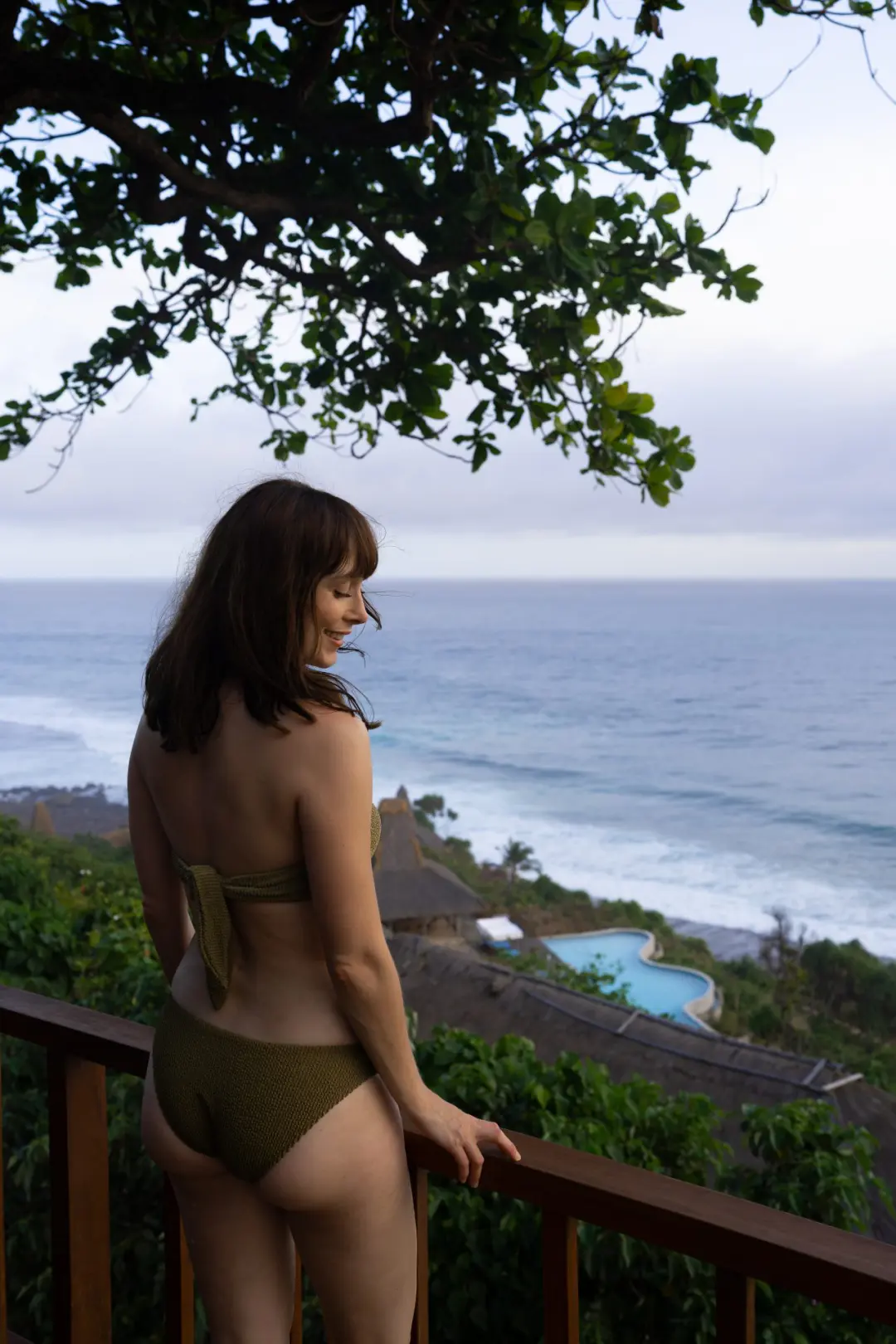 Bali vs Sumba: Travel Blogger Jordan Gassner smiling from a balcony overlooking a beachfront resort on Sumba, Indonesia