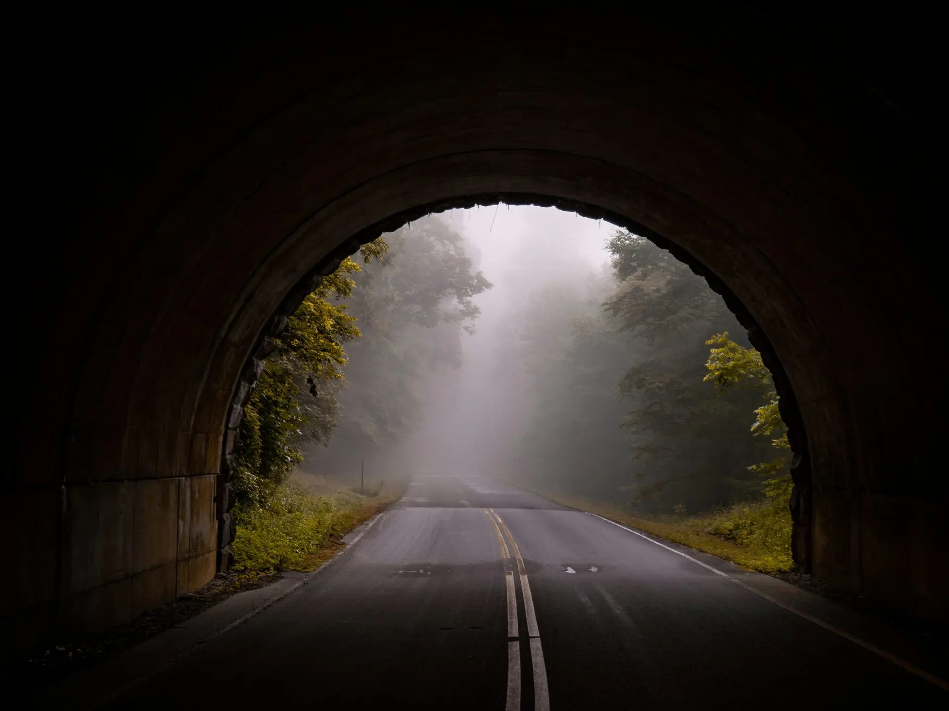 2026 Travel Trends: Mystery Trips - A road stretching out of a tunnel and leading toward a foggy unseen destination