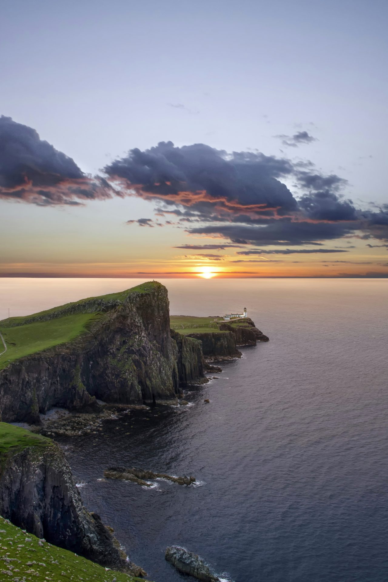 A lighthouse at sunset along the Isle of Skye in Scotland