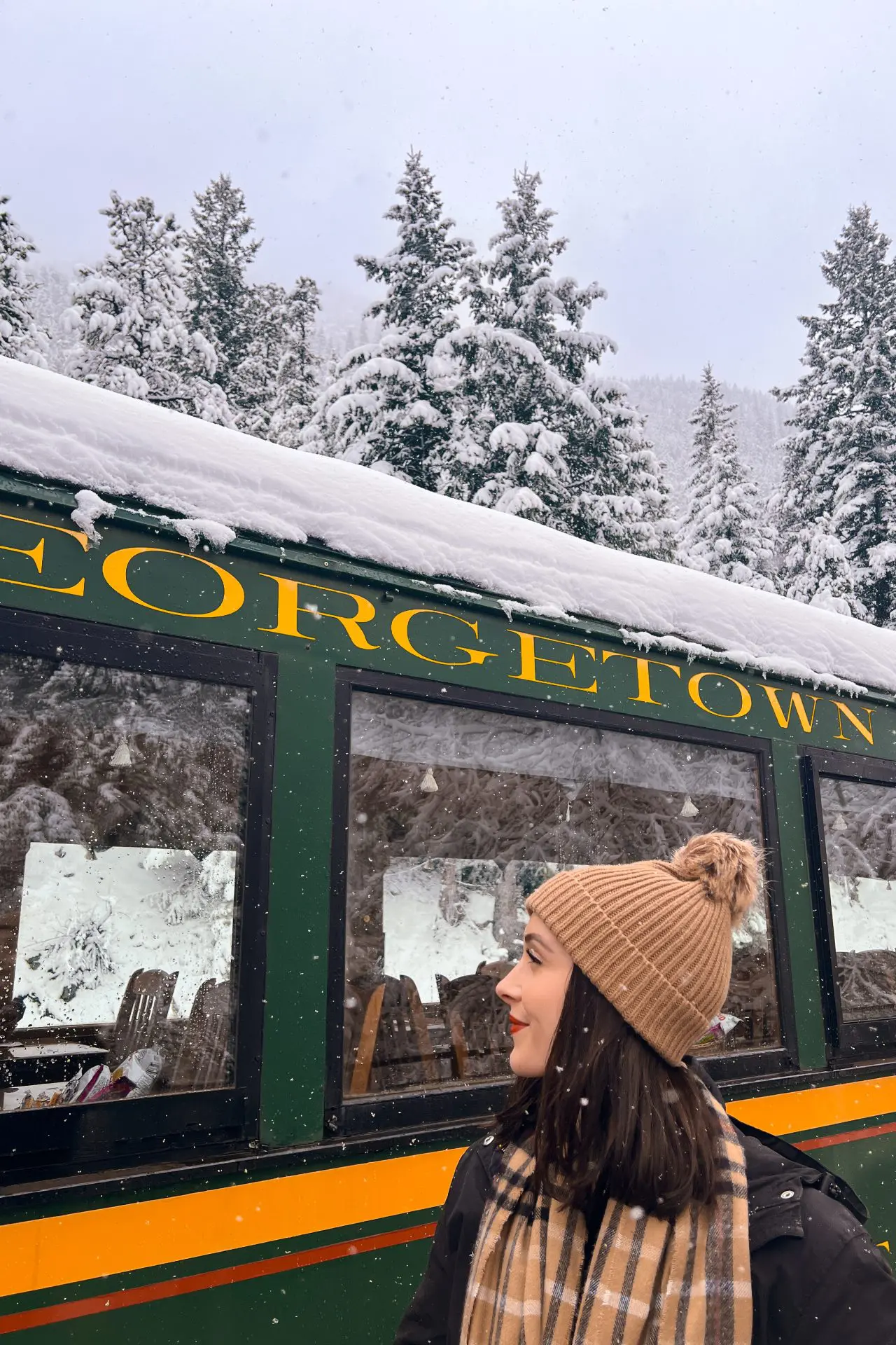 Travel Blogger Jordan Gassner looking toward the Georgetown Loop Railroad on a snowy day in Georgetown, Colorado