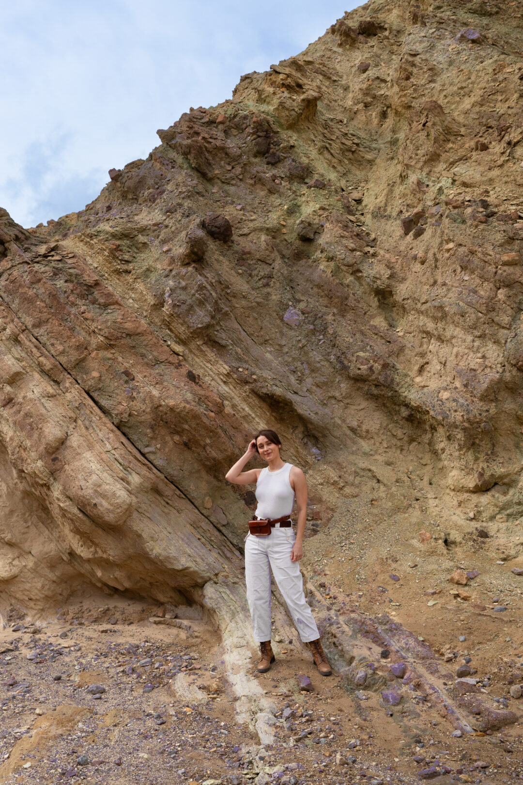 Travel Blogger Jordan Gassner standing near a group of purple rocks inside Golden Canyon in Death Valley National Park
