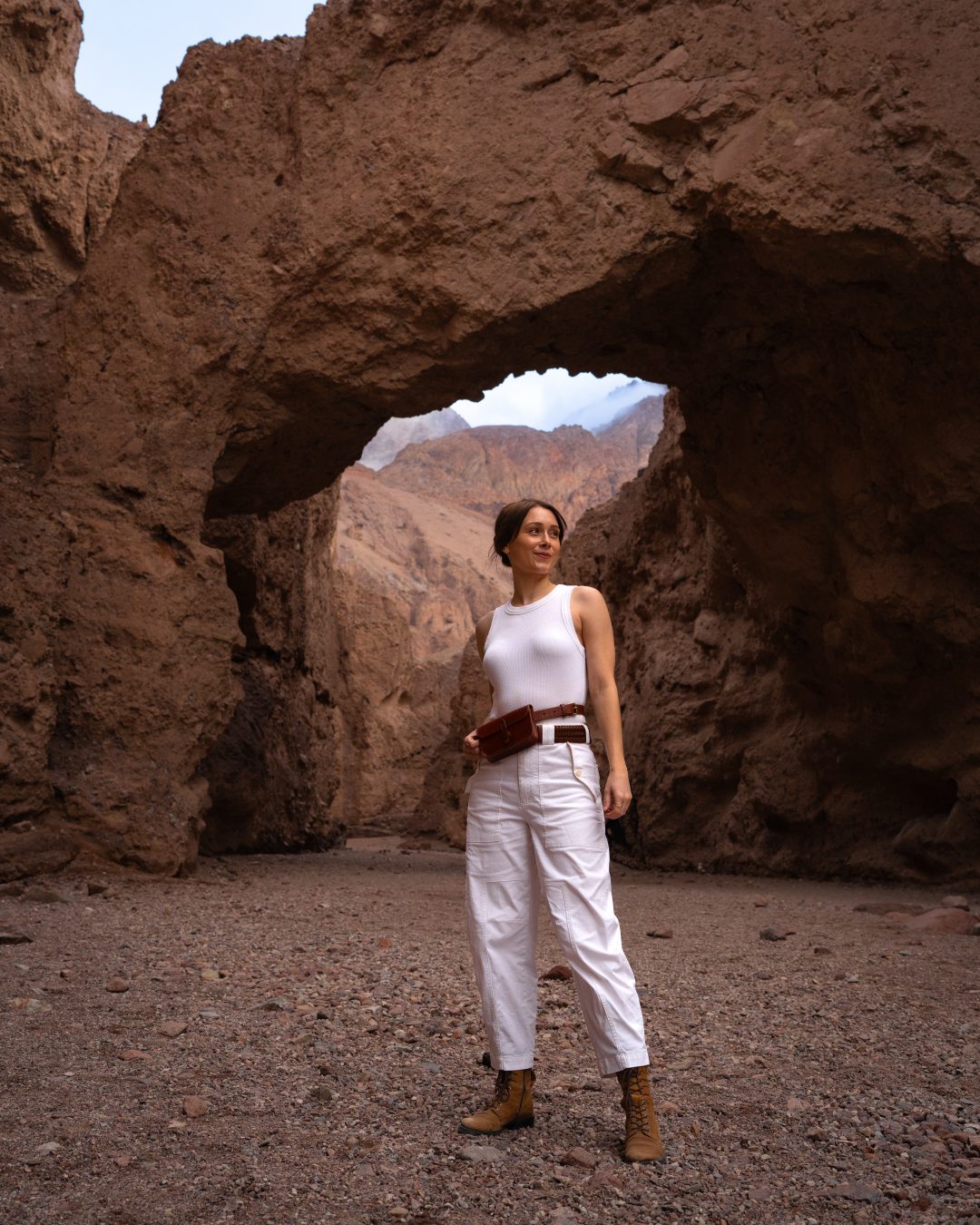 Travel Blogger Jordan Gassner standing underneath the Natural rock Bridge in Death Valley National Park in California