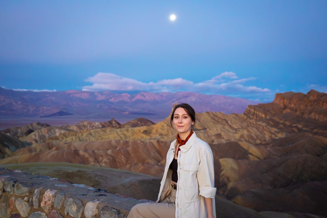 Best Things to do in Death Valley: Travel Blogger Jordan Gassner smiling from the top of Zabriskie Point in Death Valley National Park at sunrise