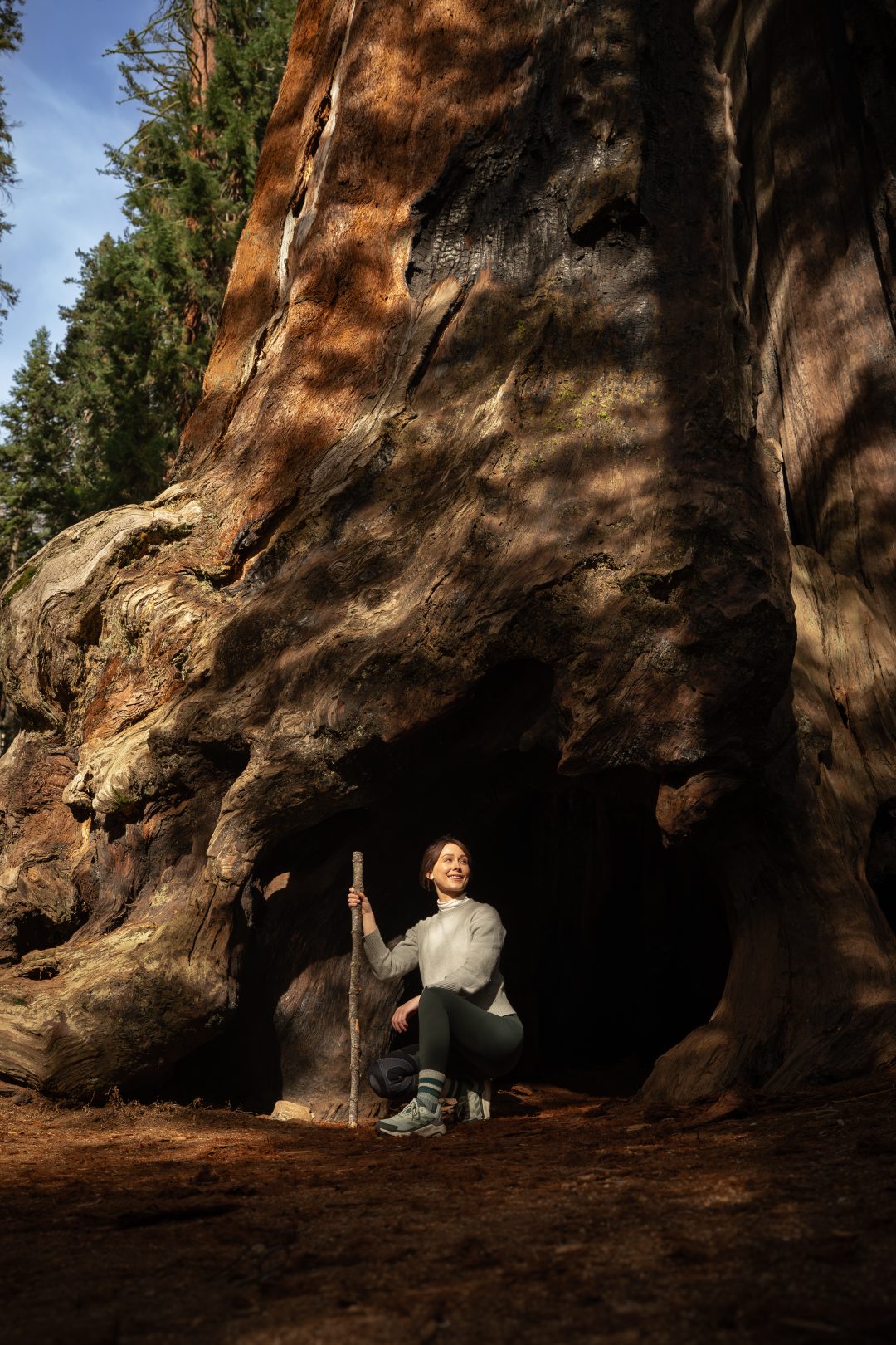 Travel Blogger Jordan Gassner squatting at Chimney Tree during a Sequoia National Park Trip