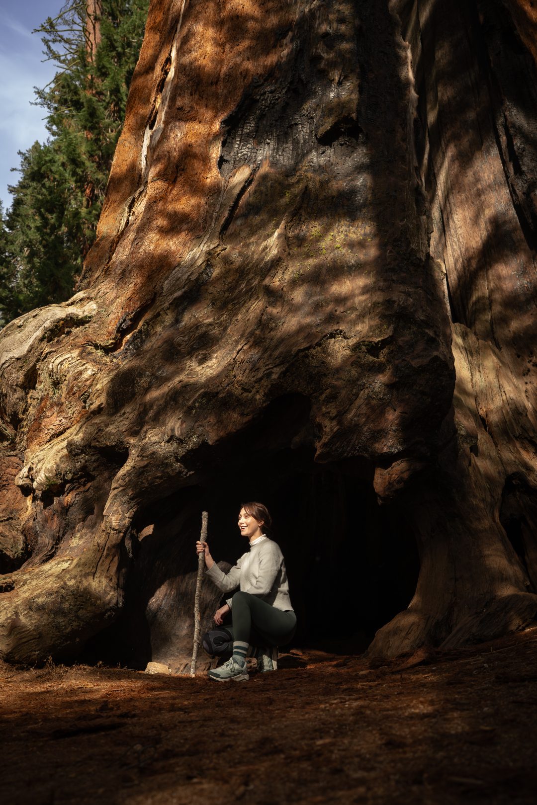 Travel Blogger Jordan Gassner squatting at Chimney Tree during a Sequoia National Park Trip