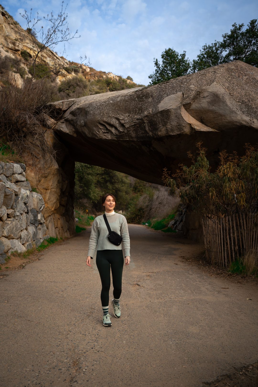 Travel Blogger Jordan Gassner walking underneath the Tunnel Rock during a Sequoia National Park Trip