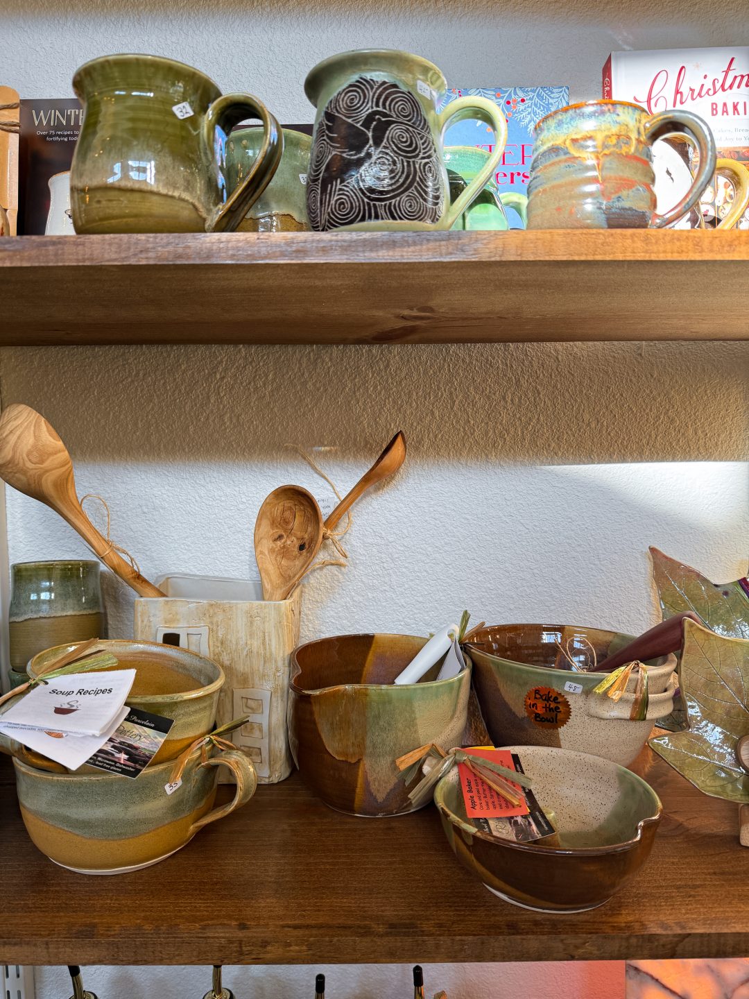A group of ceramic bowls, mugs, and cooking utensils inside Stem + Stone in Three Rivers, California