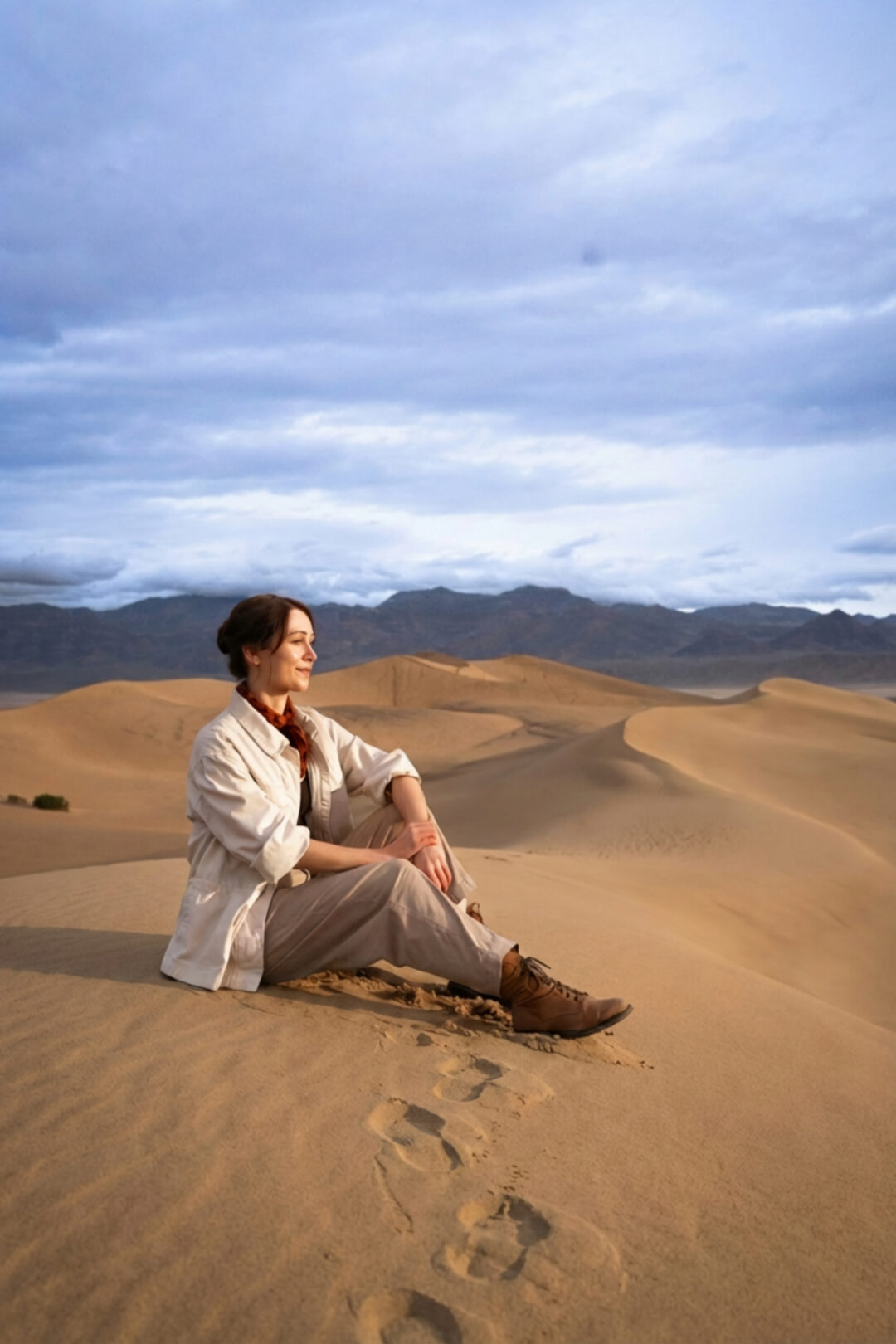 Travel Blogger Jordan Gassner sitting on top of a sand dune at Mesquite Flat Sand Dunes in Death Valley National Park