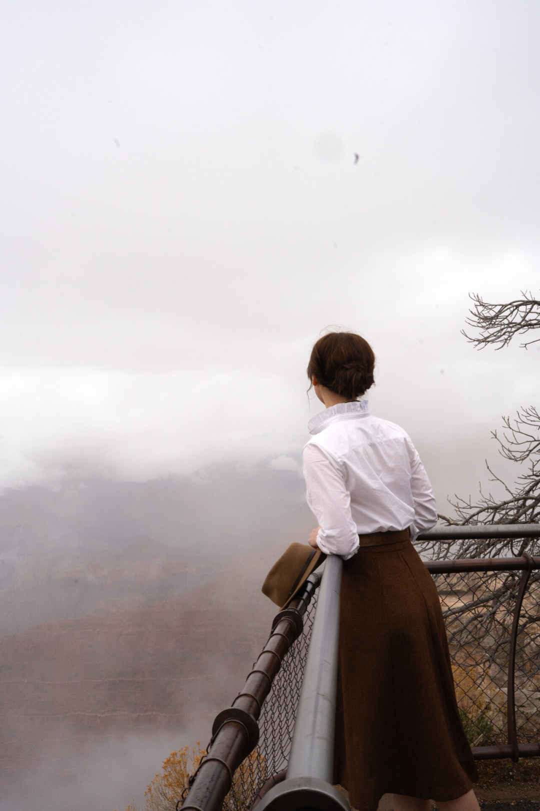 Travel Blogger Jordan Gassner looking out from a railing at Mather Point in the Grand Canyon