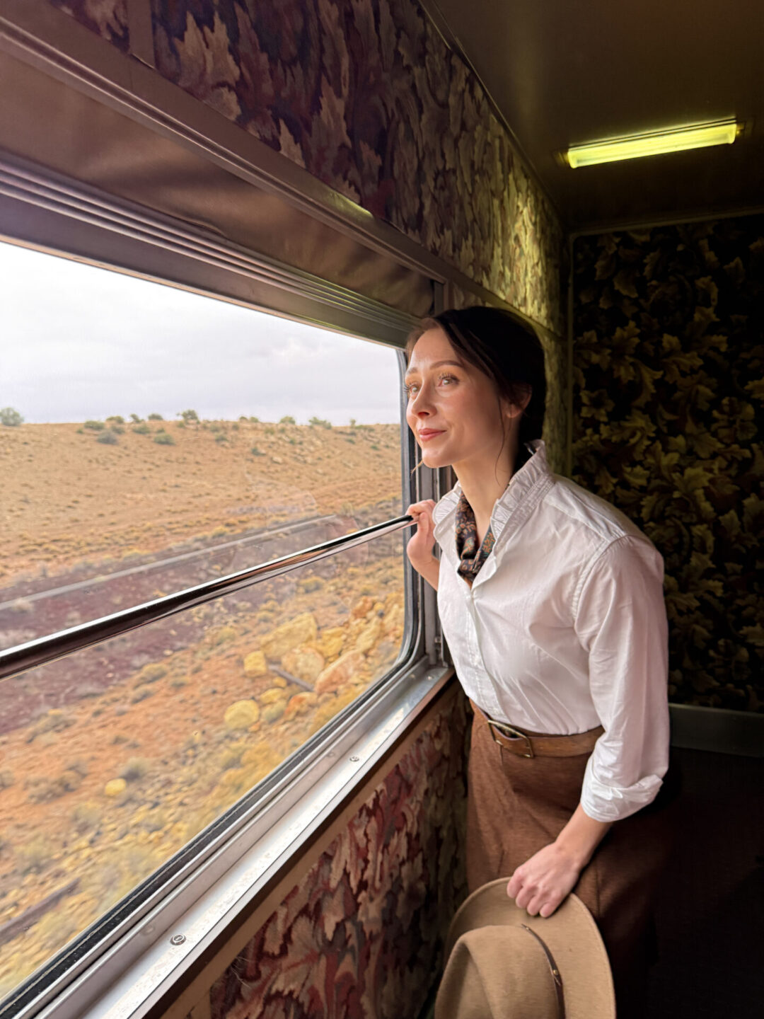 Travel Blogger Jordan Gassner looking out from a railcar window aboard the Grand Canyon Railway