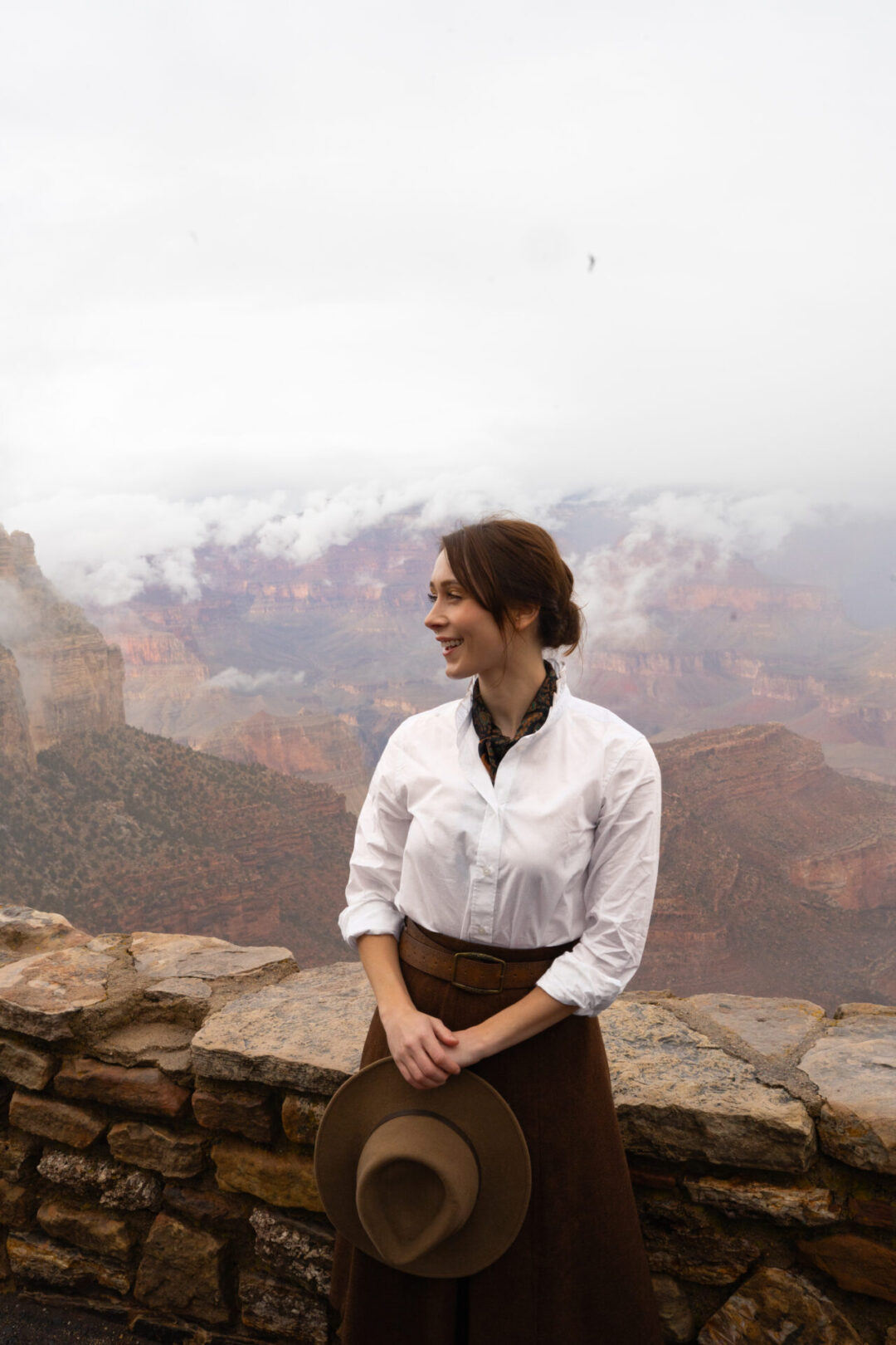 Grand Canyon in Winter: Travel Blogger Jordan Gassner smiling in front of a lookout point at the Grand Canyon