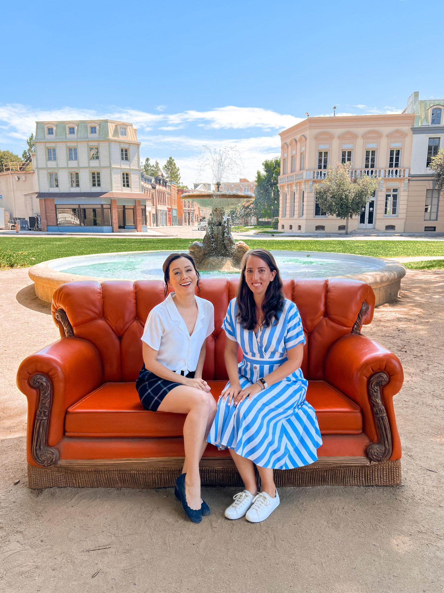 Travel Blogger Jordan Gassner and her friend Kate sitting in front of the iconic Friends fountain on the Warner Bros. Studio Backlot