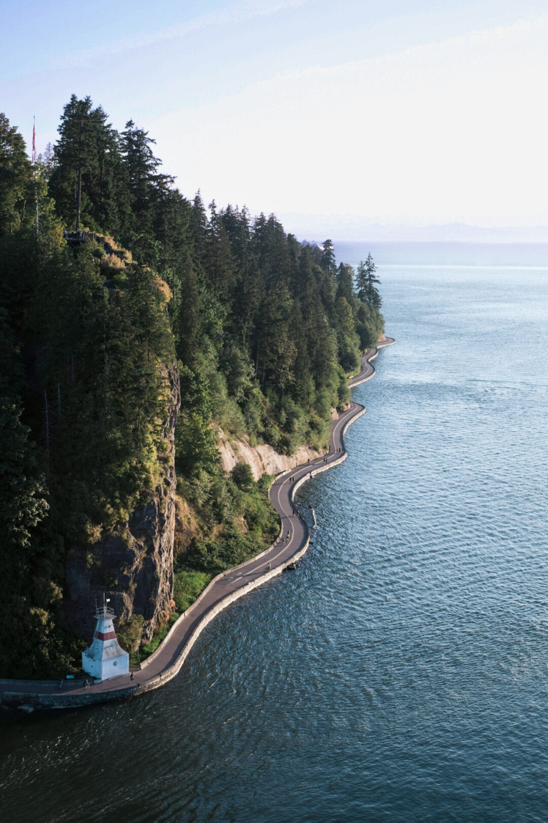 The seawall curving around the Brockton Point Lighthouse in Stanley Park in Vancouver, Canada on a clear day
