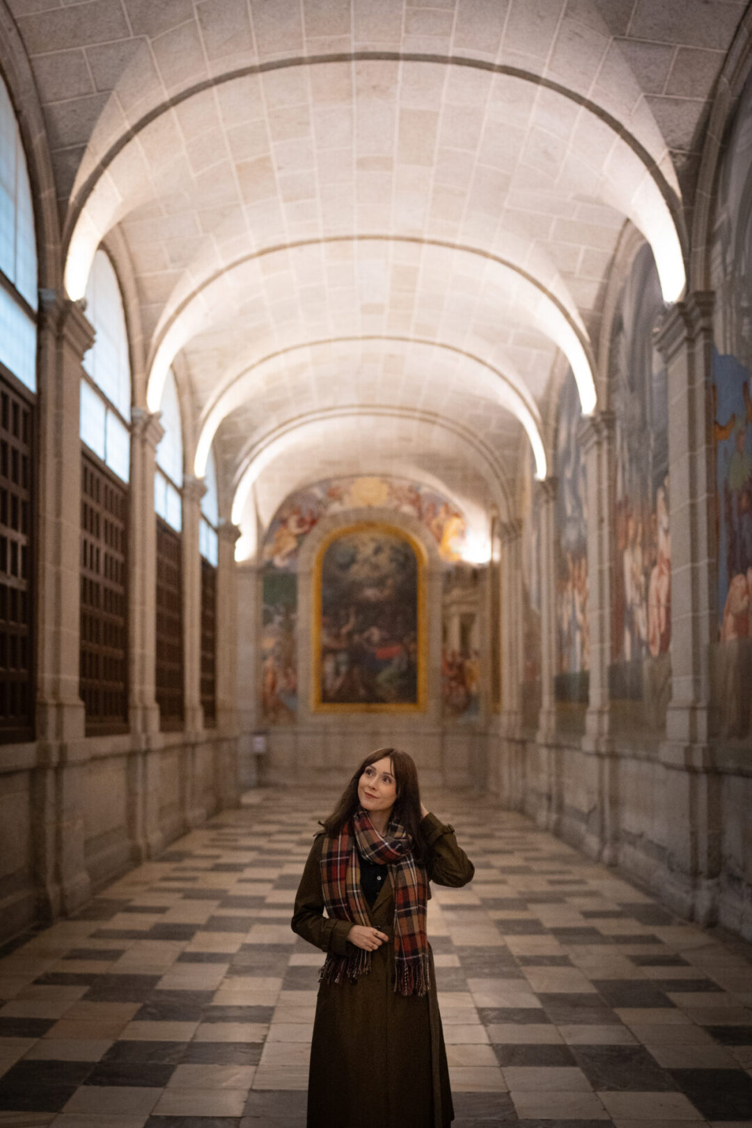 Travel Blogger Jordan Gassner walking around a long hallway inside El Escorial in Spain