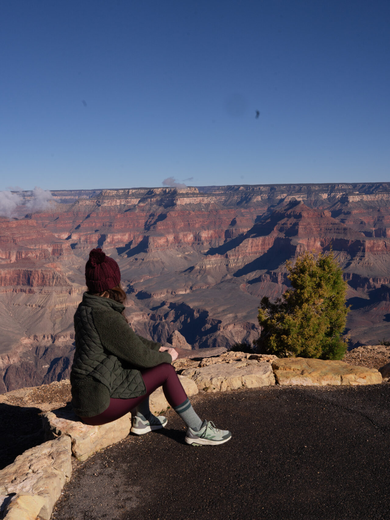 Travel Blogger Jordan Gassner sitting along a hiking path of Maricopa Point in the Grand Canyon