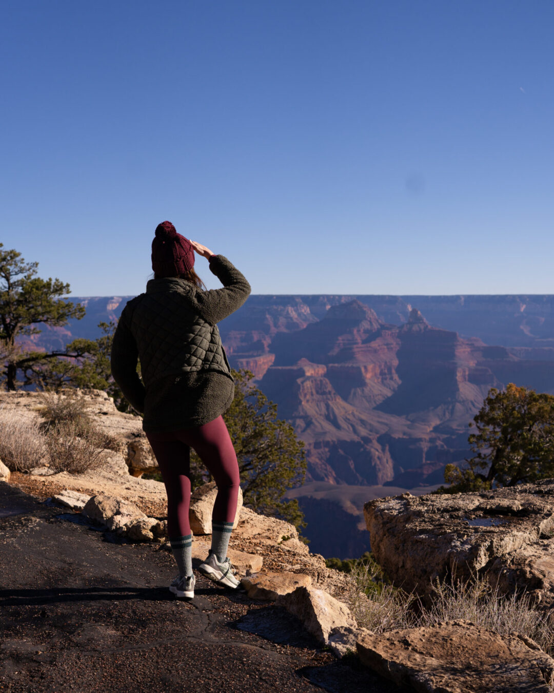 Grand Canyon Mistakes to Avoid: Underestimating the Hike Back Up. A photo of Travel Blogger Jordan Gassner looking out at the Grand Canyon from Maricopa Point 