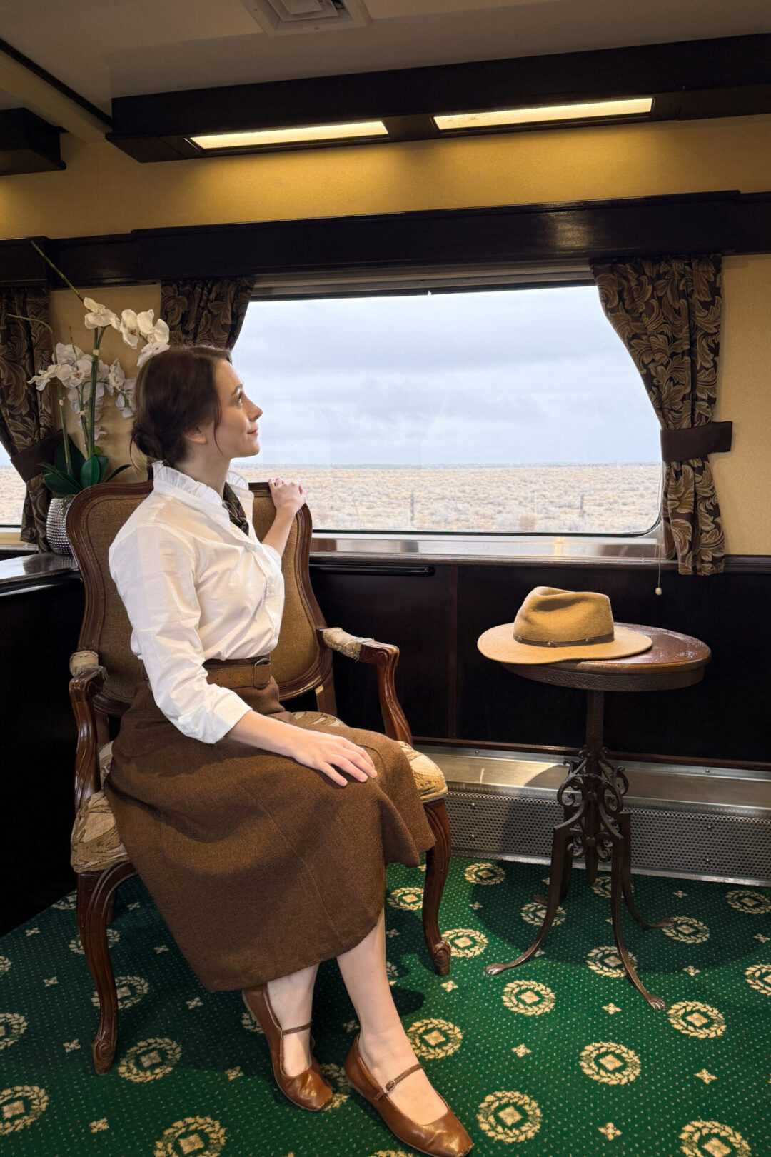 Travel Blogger Jordan Gassner sitting in a armchair inside a luxury parlor car aboard the Grand Canyon Railway