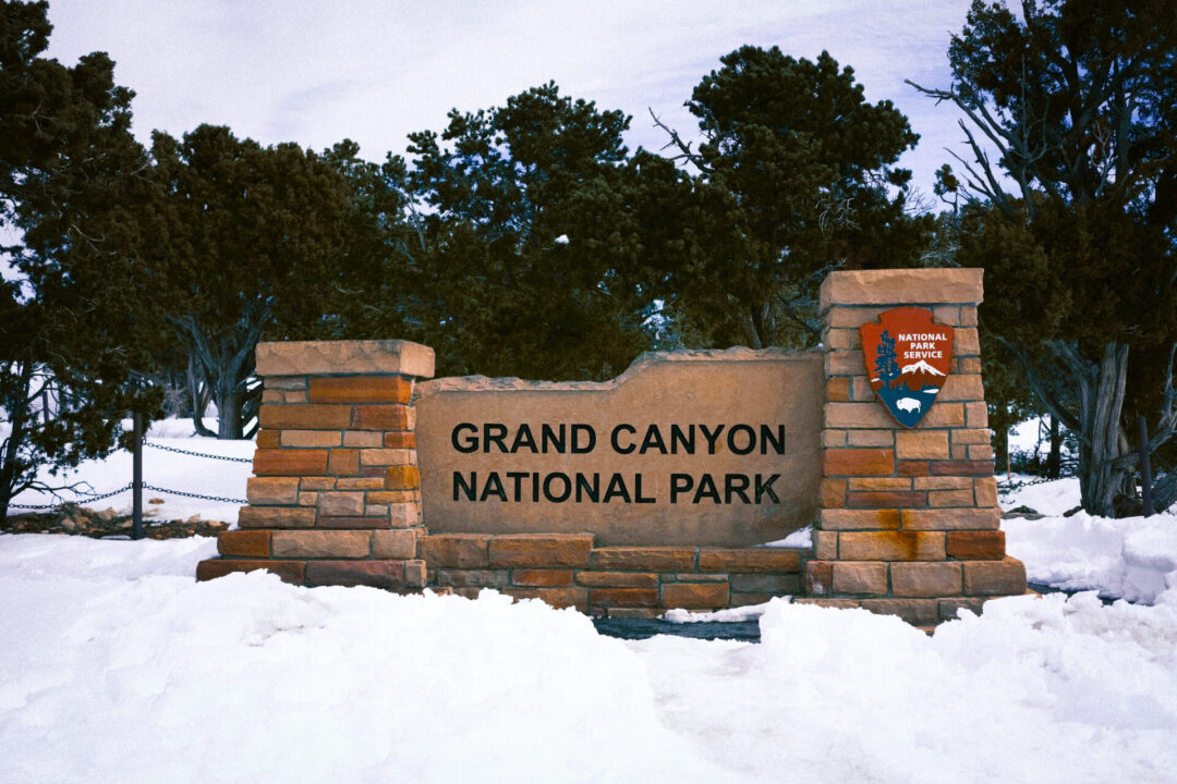 The Grand Canyon National Park sign surrounded by snow