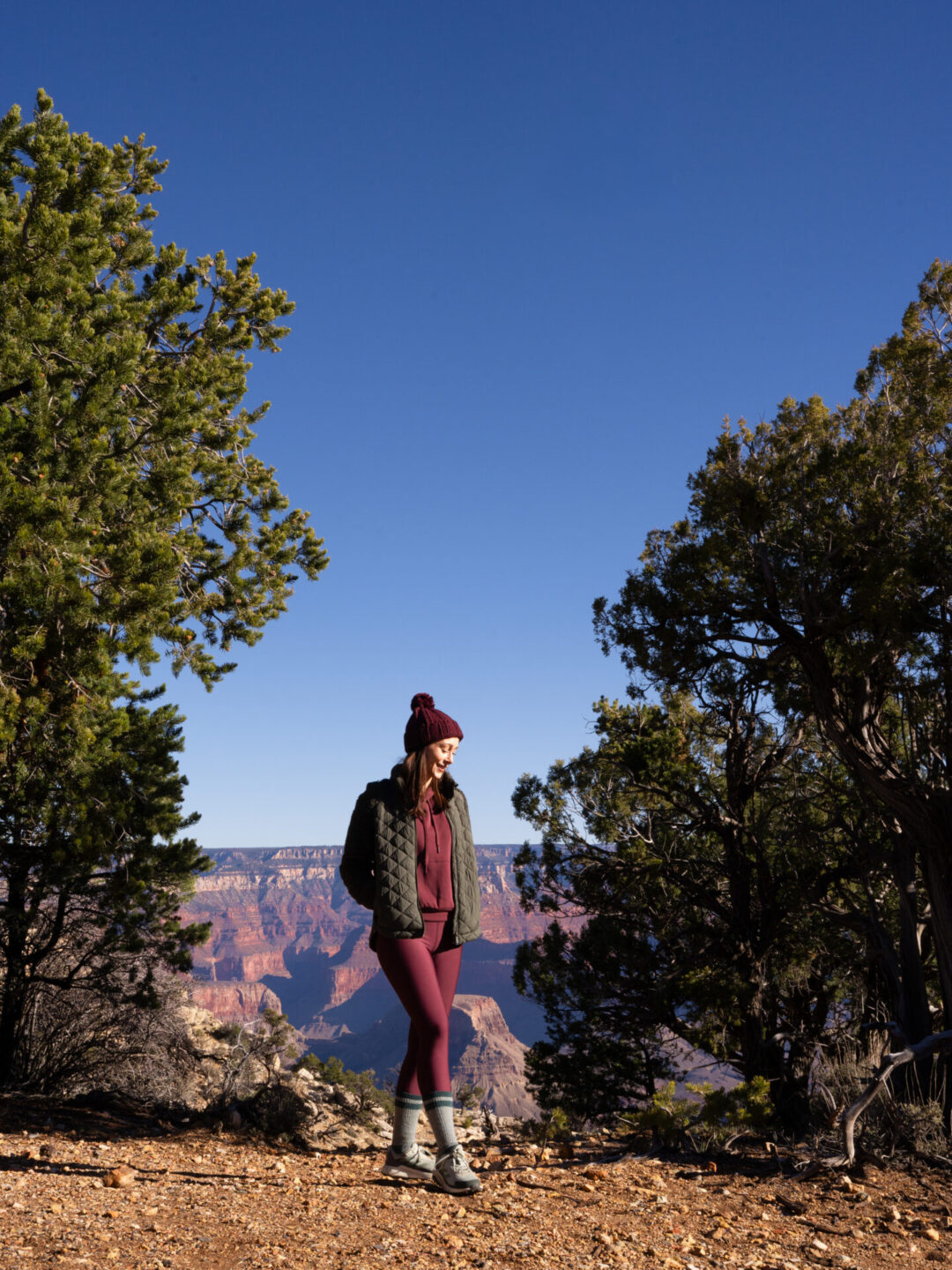 Travel Blogger Jordan Gassner smiling while standing between two trees near Maricopa Point at the Grand Canyon in Arizona, USA