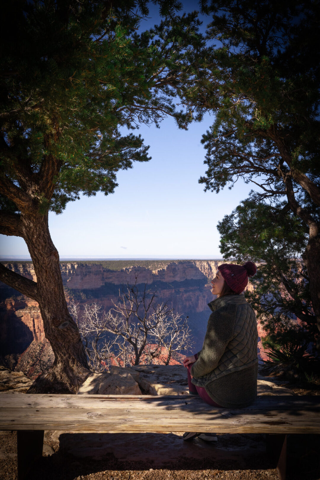 Travel Blogger Jordan Gassner sitting on a bench i nthe shade at Mohave Viewpoint at the Grand Canyon