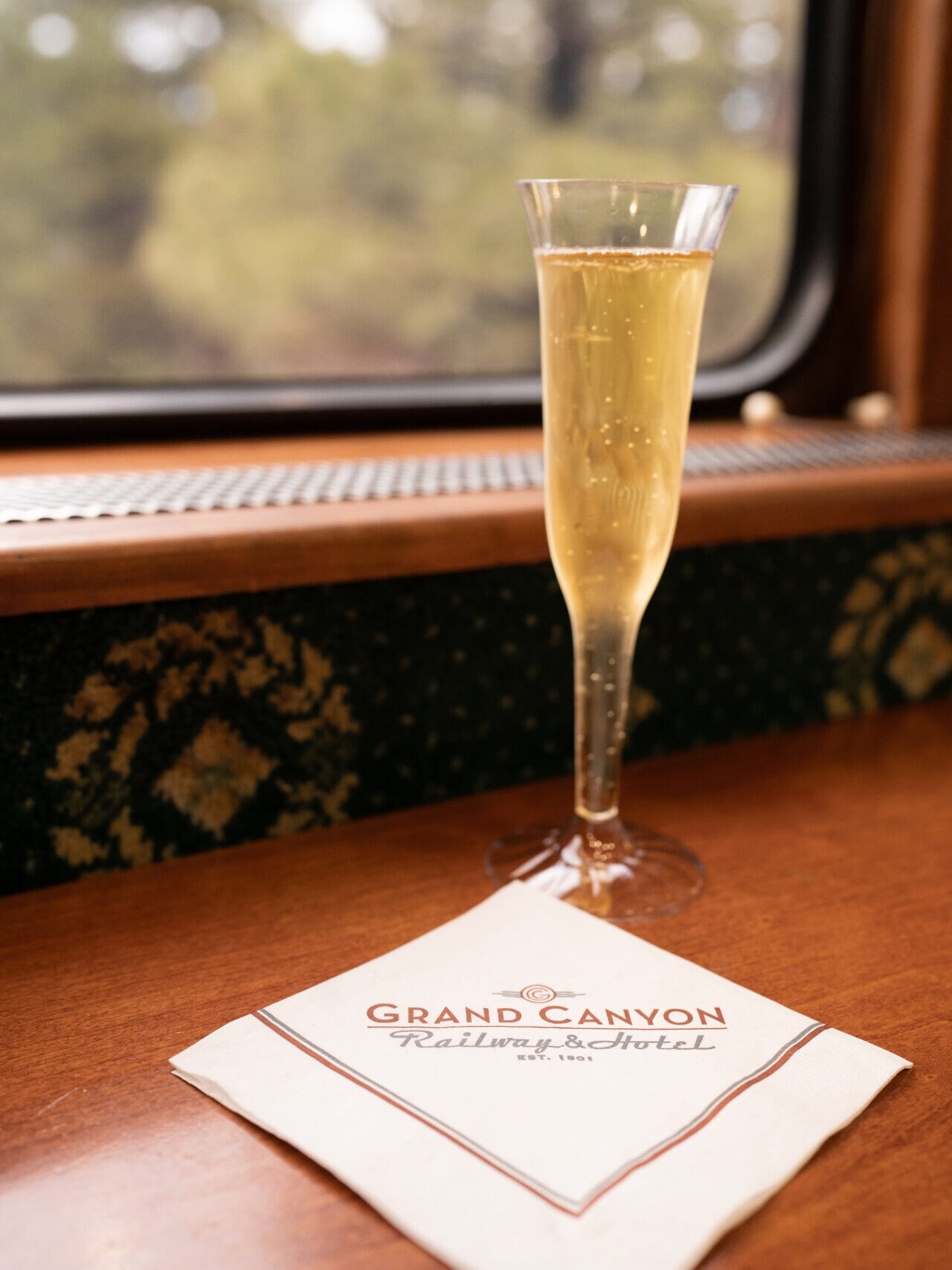A full champagne flute and a "Grand Canyon Railway & Hotel" napkin