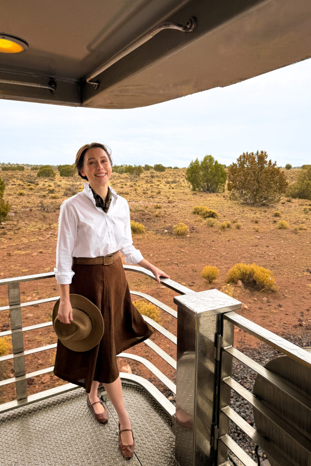 Travel Blogger Jordan Gassner smiling from the observation deck while aboard the back of the Grand Canyon Railway