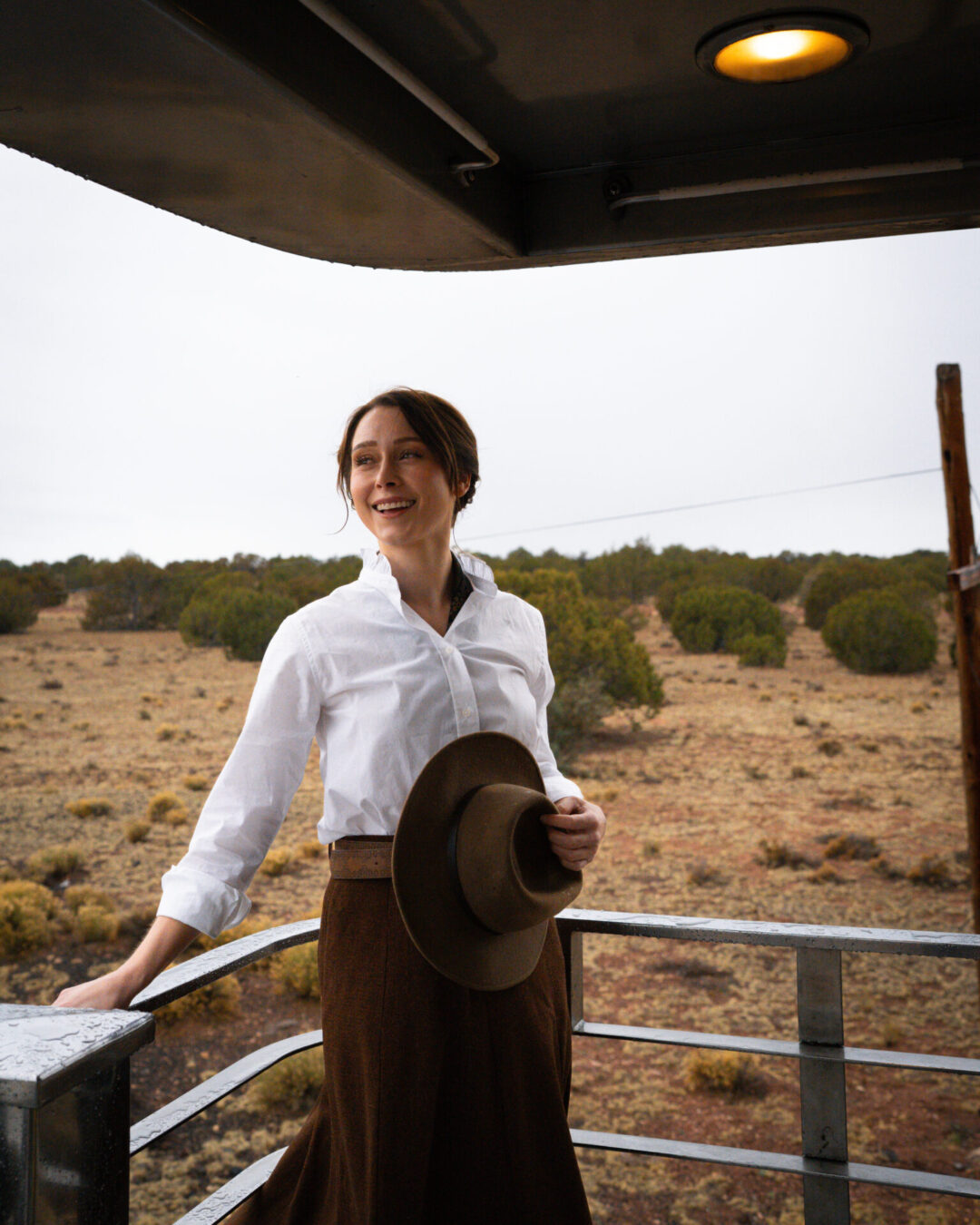 Travel Blogger Jordan Gassner smiling and holding her cowboy hat aboard the Grand Canyon Railway in Williams, Arizona