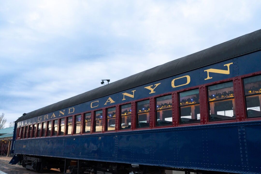 A blue Grand Canyon Railway car at the Williams, Arizona depot decorated on the inside with festive Christmas lights