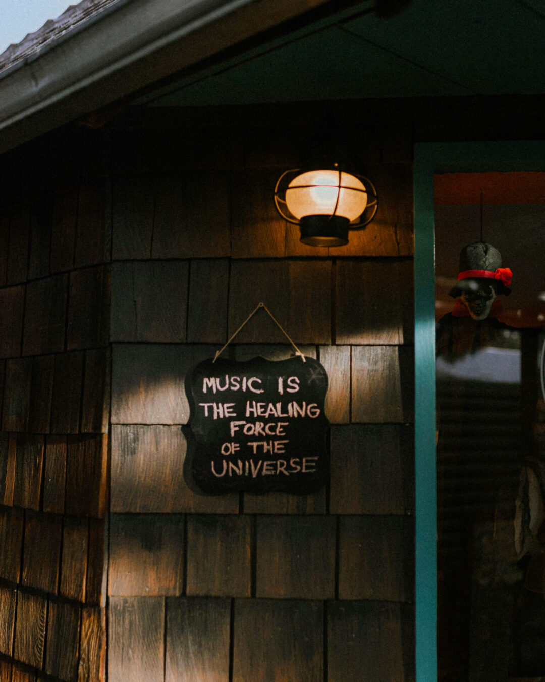 A sign "Music is the healing force of the universe" hanging from a cabin in Idyllwild, California