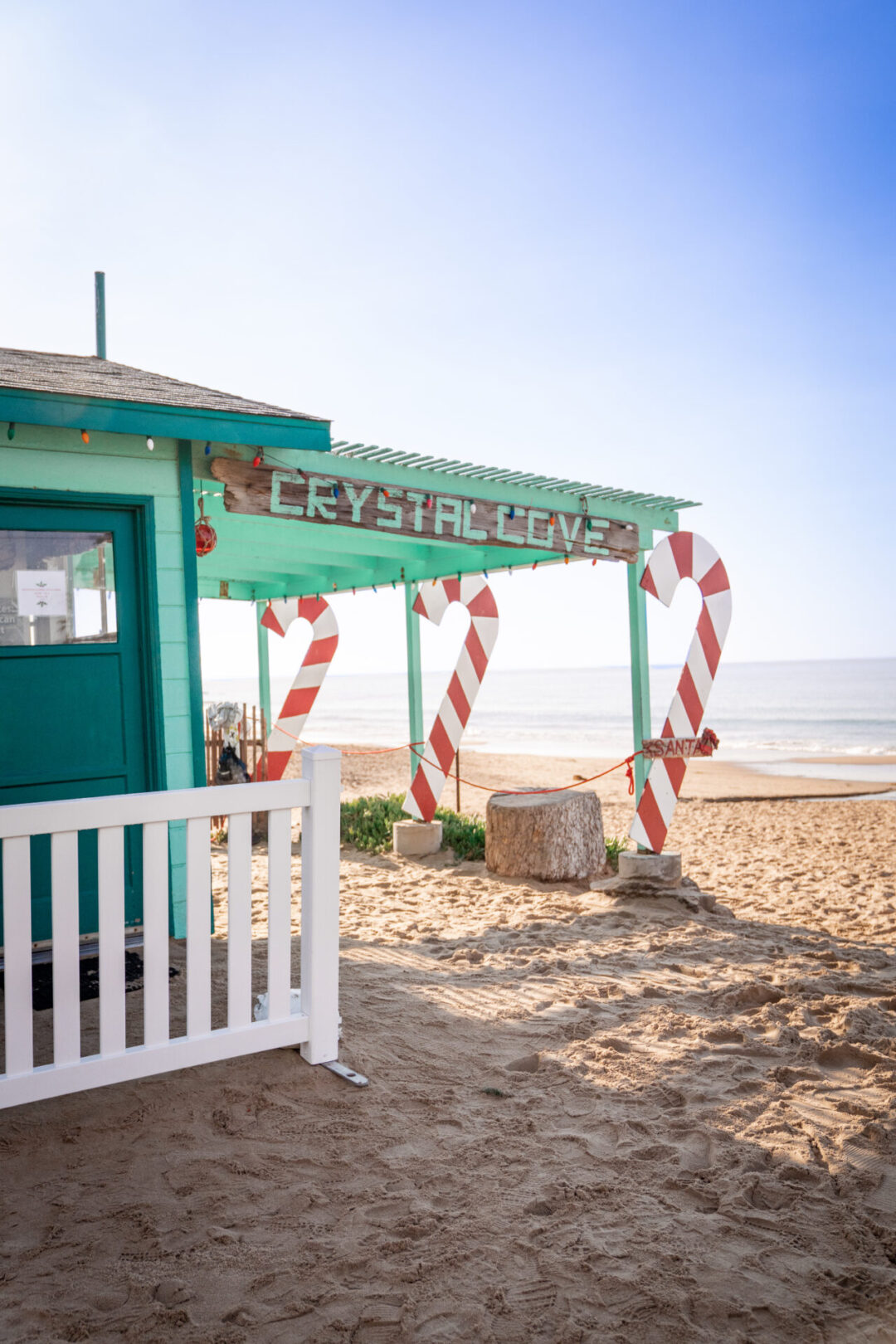The turquoise Crystal Cove shack decorated in lights and giant candy canes along the Crystal Cove Beach near Laguna Beach, California