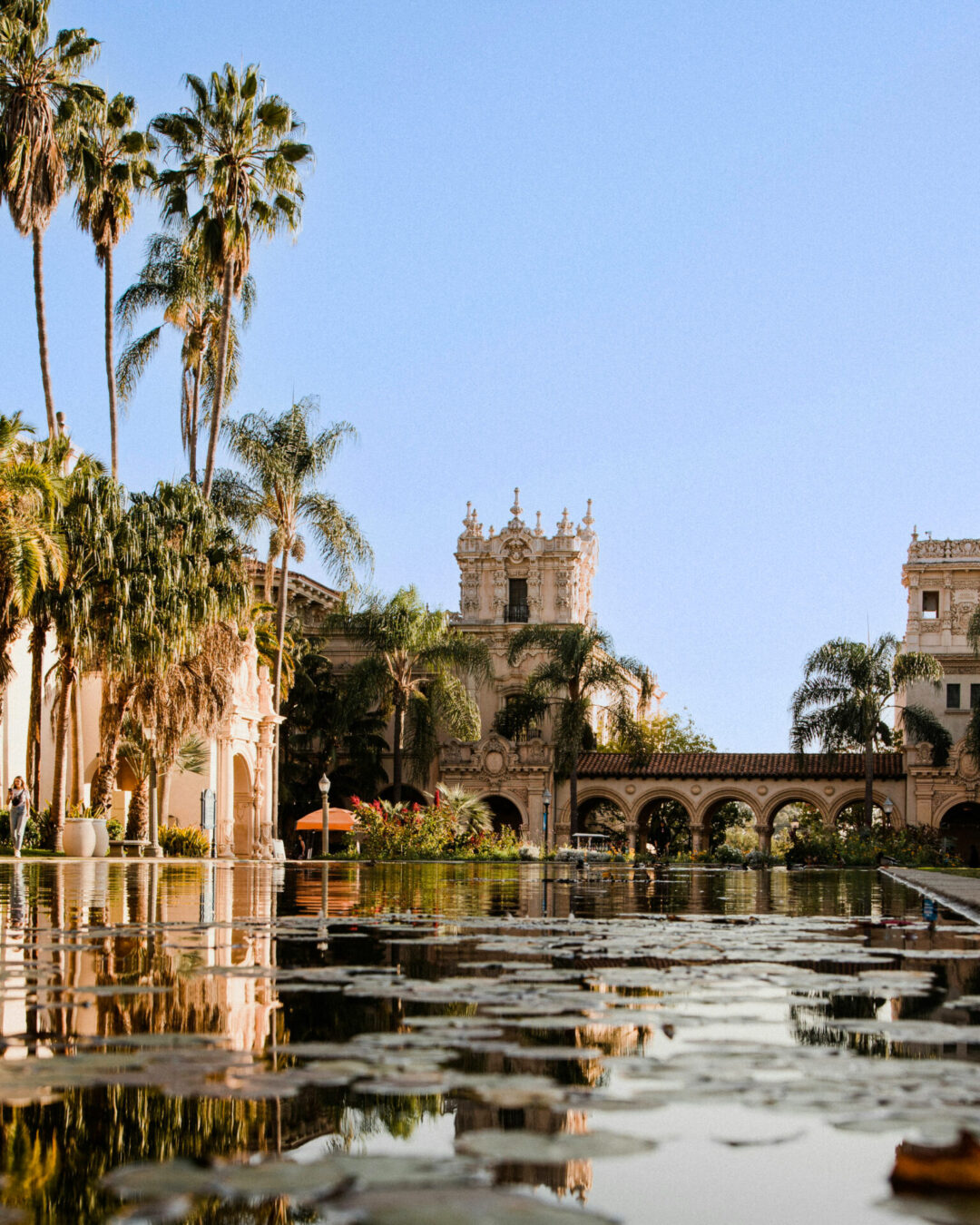 A pond in front of Spanish Colonial architecture inside Balboa Park in San Diego, California