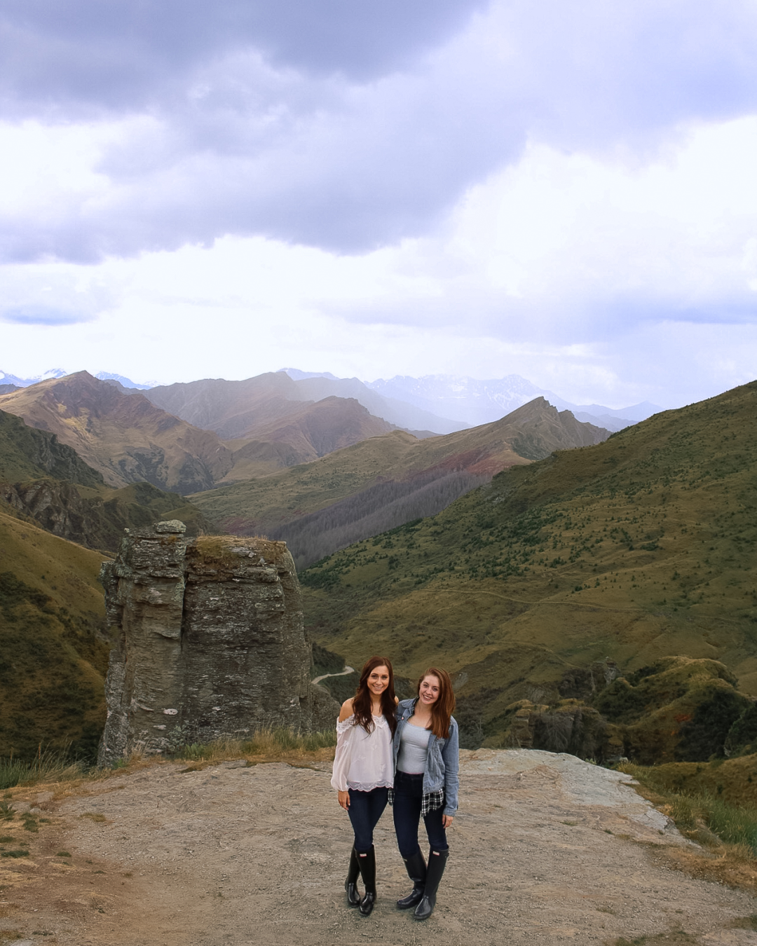 Travel Blogger Jordan Gassner and a friend smiling at the beginning of the Skippers Canyon Road in Queenstown, New Zealand