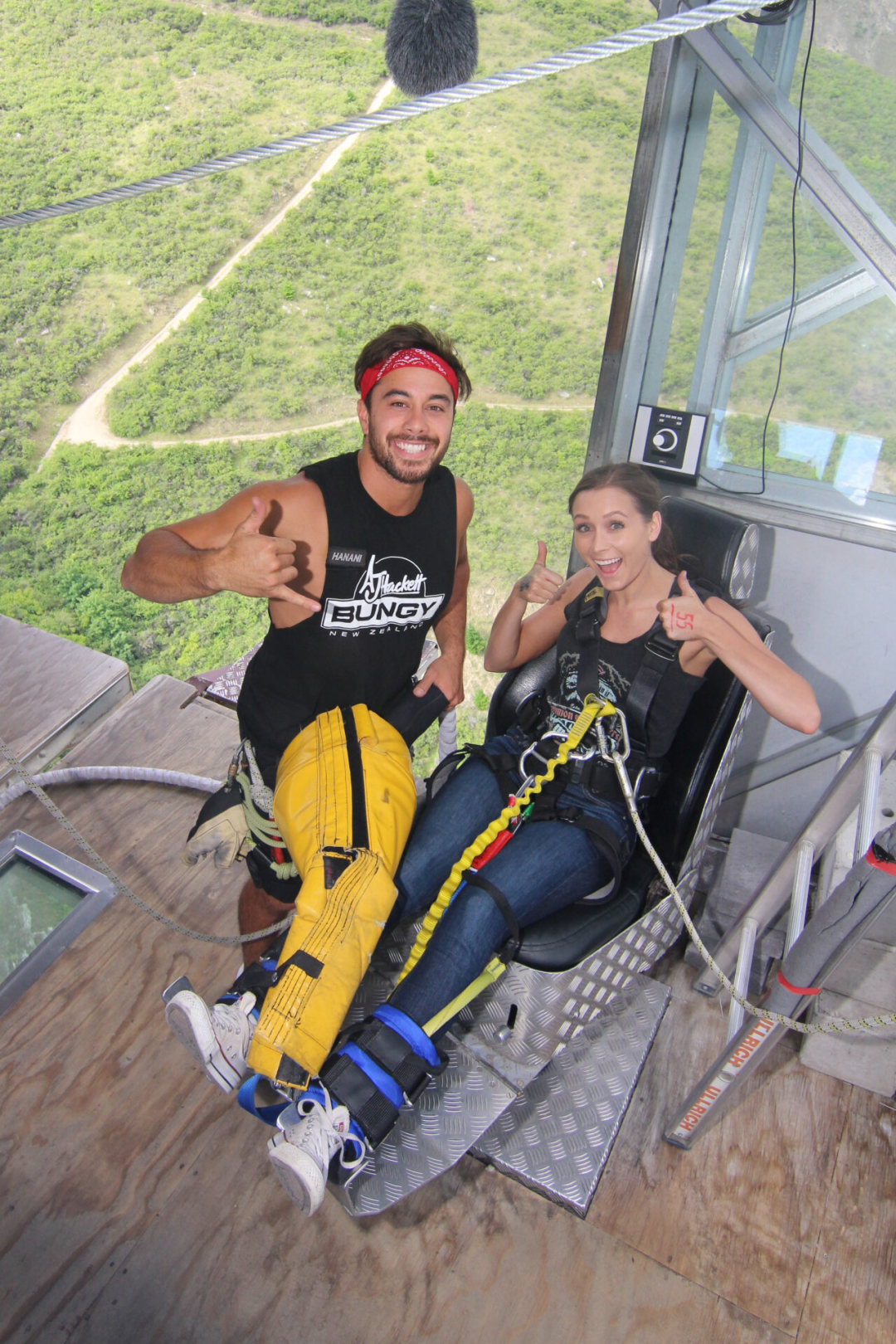Travel Blogger Jordan Gassner giving two thumbs up while getting fitted in bungy jump gear at the Nevis Bungy in Queenstown, New Zealand