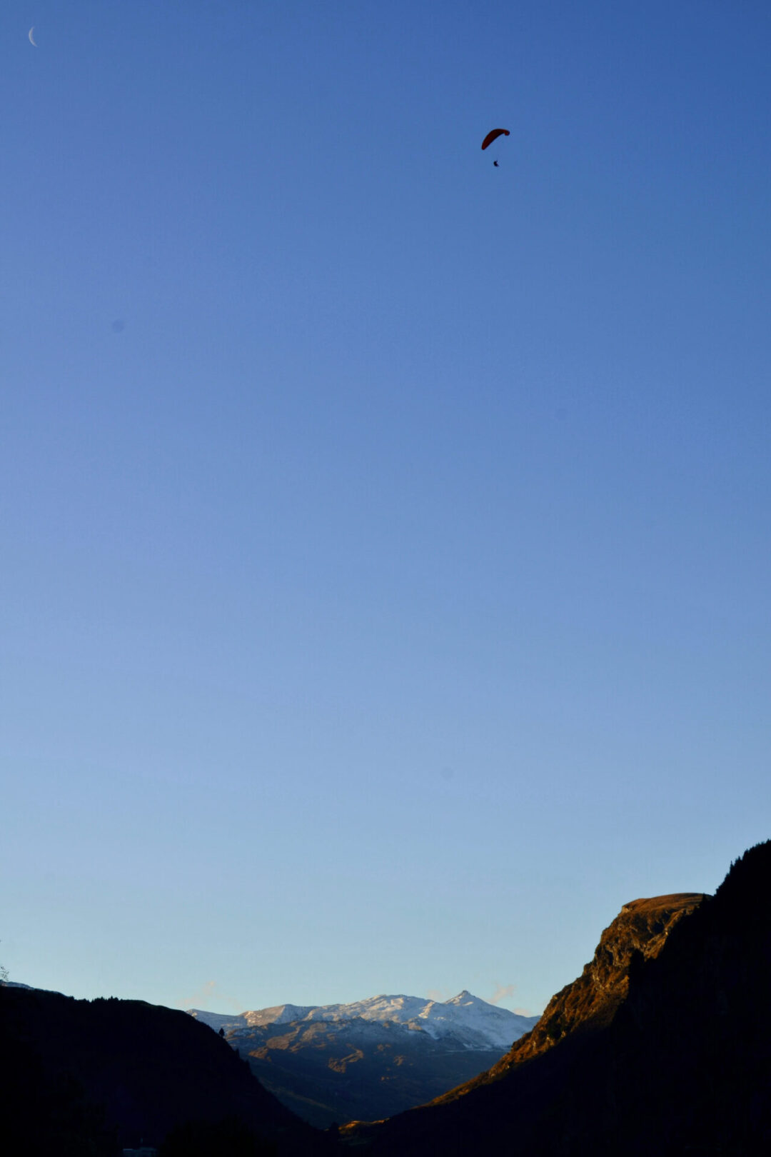 A sky diver high above the Remarkables near Queenstown, New Zealand